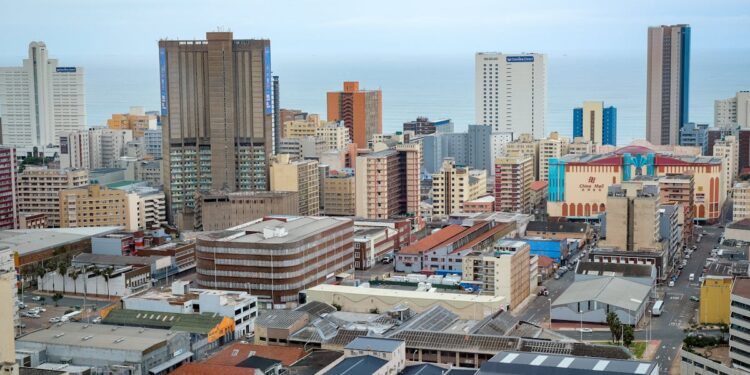 Panoramic view of Durban's modern skyline showcasing high-rise buildings and ocean backdrop.