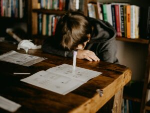 Parent guiding child at home with books and laptop – how to do homeschool effectively