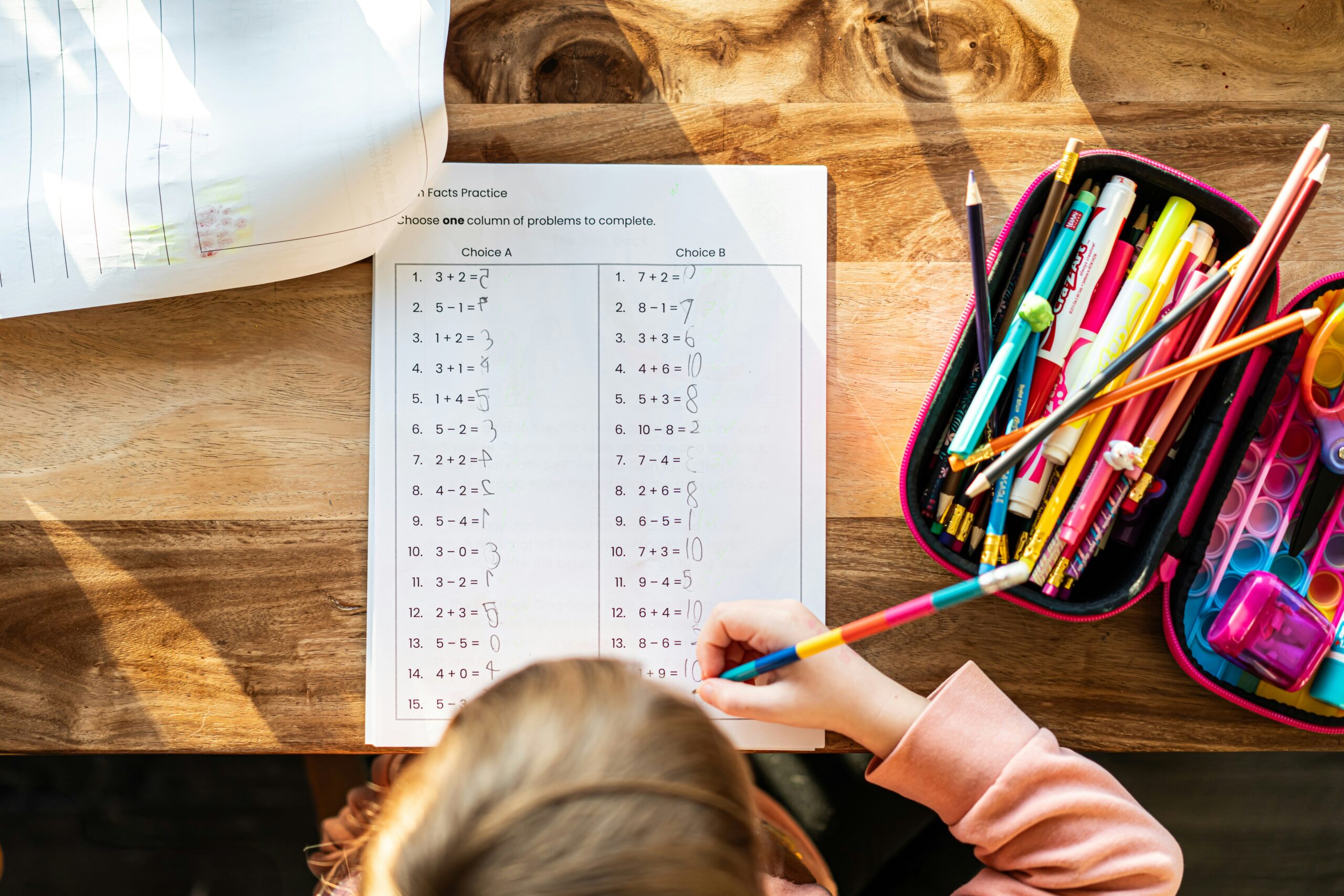 Parent guiding child at home with books and laptop – how to do homeschool effectively